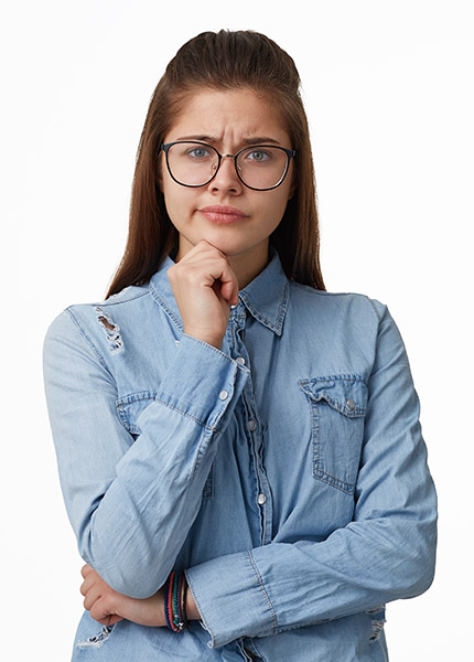 Portrait of a girl with glasses who are unhappy with what is happening is having crossed one hand with the other one holding the chin one corner of the lips pursed, dressed in a denim shirt isolated on a white background